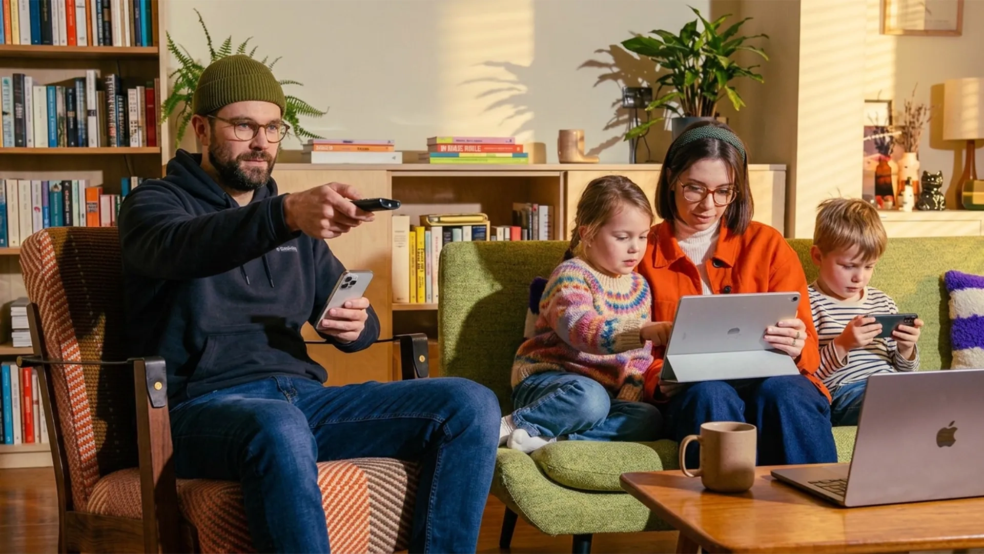 A family sitting on a sofa and working with their gadgets and electronics